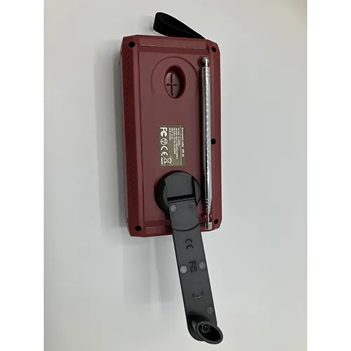 Radio Maroon/burgundy cu detalii negre. Echipat cu o manivelă, panou solar, antenă, curea textilă și o fereastră mică de afișare. Include un cablu USB/USB-C negru.