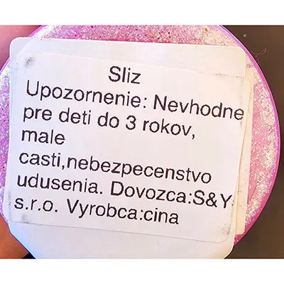 Mâzgă roz cu bile mici colorate în capacul de plastic al jucăriei.