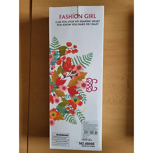 Păpușă de aproximativ 29 cm, cu accesorii din plastic, cercei din plastic de culoare argintie pe urechi, păr lung blond într-o coadă de cal, îmbrăcată într-o rochie mini și pantofi de plastic roz cu talpă înaltă și tocuri.