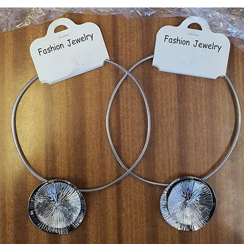 Colier rotund din metal cu pandantiv metalic în formă de două cercuri conectate de culoare argintie.