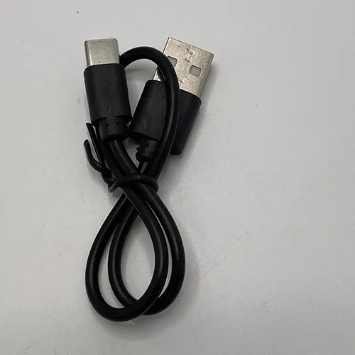 Lampă de cap cu un cablu utilizat pentru încărcarea lămpii.