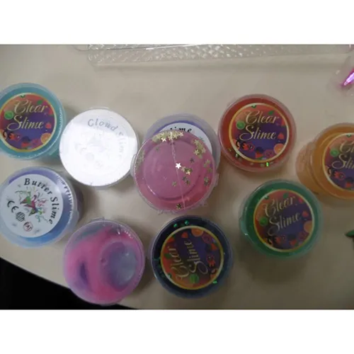 Douăsprezece vase de mâzgă colorată de jucărie cu saci mici de decorațiuni. Produs vândut online, în special prin intermediul Amazon (ASIN: B0D6Z7HC9M).