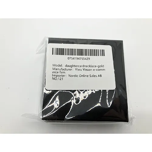 Colier de culoare aurie cu un farmec în formă de inimă împânzit cu pietre.