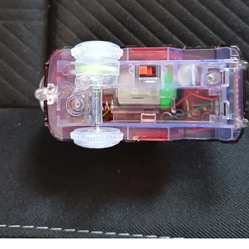 Jucărie din plastic acționată de baterii, sub forma unei mașini prevăzute cu o pistă din plastic, baterii ușoare și baterii AA.