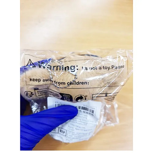 Jucărie de pluș, în formă de catelus maro, cu ochelari negri și un guler cu un clopot. Produs vândut online, în special prin intermediul Shein.