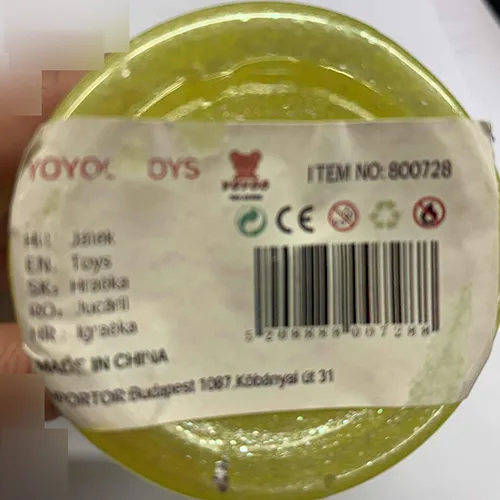 Mâzgă galbenă de jucărie ambalată într-un recipient din plastic cu un capac verde decorat cu urechi și modele de stele.