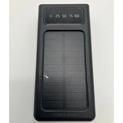 Powerbank negru, de aproximativ 25 cm lungime, cu un panou solar, ecran LCD și patru cabluri de &icirc;ncărcare &icirc;ncorporate și ieșiri USB duble. Produs v&acirc;ndut online, &icirc;n special prin intermediul ovbutiken.se.