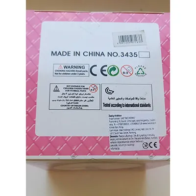 Păpușă din plastic cu ochi pictați și buze roșii, purt&acirc;nd o rochie.