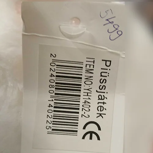 Jucărie albă de pluș &icirc;n formă de urs cu guler roșu &icirc;mp&acirc;nzit cu știfturi &icirc;n formă de os.