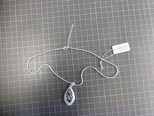 Colier metalic argintiu cu pandantive metalice argintii, negre și aurii, &icirc;nchidere și prelungitor de lanț.