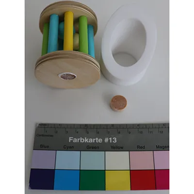 Set de jucării din lemn format dintr-un cilindru cu laturile din bare, care conține bile; o secțiune din lemn cu un suport pentru cilindru pe o parte și un cilindru rotativ cu o oglindă pe cealaltă parte Produs vândut online, în special prin intermediul montessoritoddlers.com.