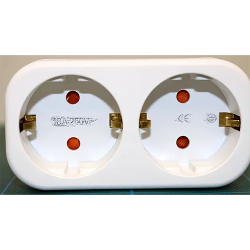 Adaptor cu soclu dublu. Dimensiuni: &icirc;nălțime x lățime x ad&acirc;ncime = aproximativ 100 mm x 45 mm x 40 mm + bază.