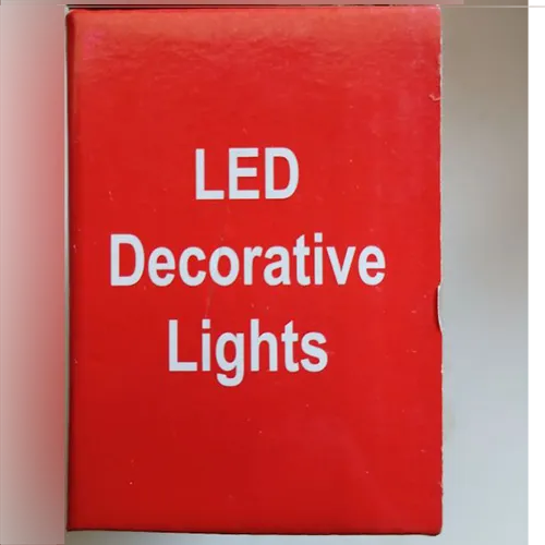 Lanț de iluminat decorativ cu 100 de LED-uri, cablaj transparent și o cutie de control albă integrată (model: EK-04) cu un buton mecanic de selectare a programului pe partea din spate și un conector end-to-end.