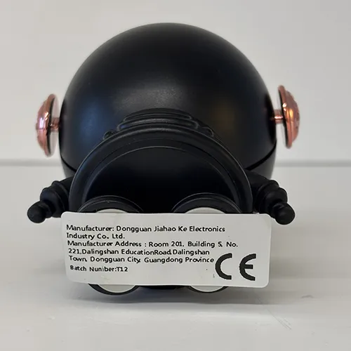 Ventilator electric negru în formă de astronaut de aproximativ 10 cm, cu cablu USB în cutie de carton.
