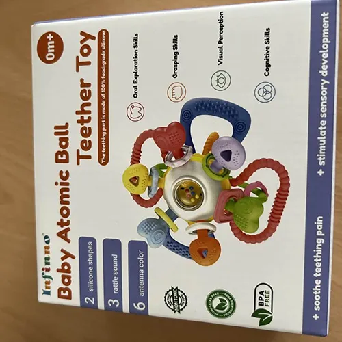 Jucărie dințată și zornăitoare, const&acirc;nd dintr-o minge care conține bile mai mici și diverse accesorii din plastic masticabil moale.