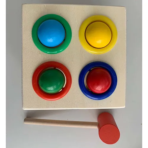 Jucărie din lemn constând dintr-o cutie cu patru deschideri circulare colorate în partea de sus, concepută pentru a primi bucăți colorate (albastru, galben, verde și roșu) în formă de bilă și un ciocan din lemn. Jucăria funcționează prin utilizarea ciocanului inclus pentru a conduce piesele în formă de bilă în cutie. Odată intrate, piesele pot fi recuperate printr-o deschidere în carcasă și folosite din nou.