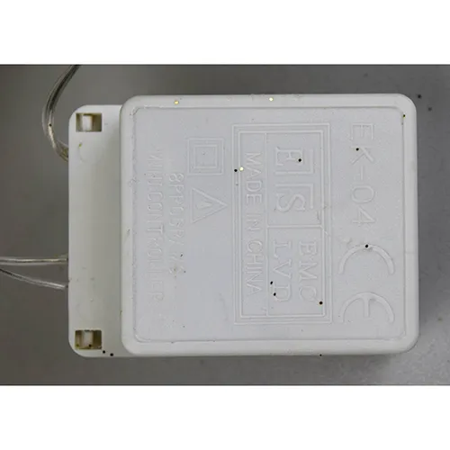 Corp de iluminat decorativ &icirc;n formă de ren cu lumini LED galbene, corp cu sclipici auriu, fire transparente izolate și o cutie electronică albă de control marcată EK-04. Produsul este livrat cu un set de extensie a cablului.