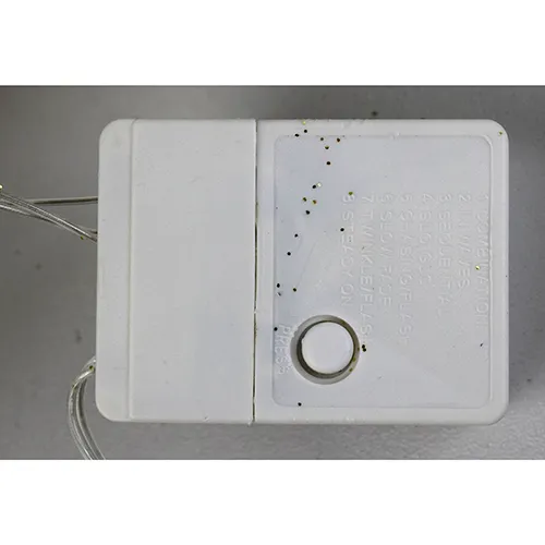 Corp de iluminat decorativ &icirc;n formă de ren cu lumini LED galbene, corp cu sclipici auriu, fire transparente izolate și o cutie electronică albă de control marcată EK-04. Produsul este livrat cu un set de extensie a cablului.