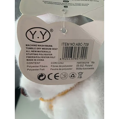 Ursuleț de pluș alb moale din material textil și umplut cu umplutură moale. Are un nas maro, marcaje decorative ale labei și o eșarfă tricotată galbenă legată &icirc;n jurul g&acirc;tului.