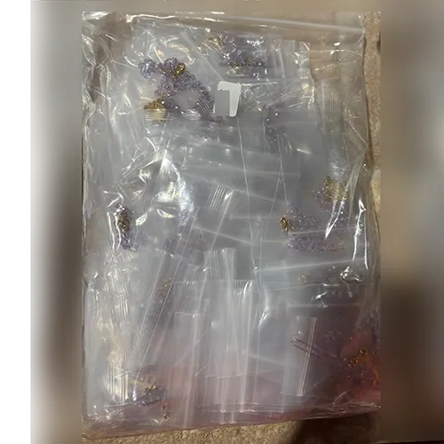 Colier rozariu cu margele de culoare violet, un pandantiv metalic rotund și o cruce metalică, vândute în vrac