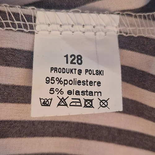 Rochie alb-negru cu dungi, destinata copiilor, cu maneci scurte, gat rotund cu cravata decorativa frontala, talie elastica si fusta nivelata. Dimensiunea 128.