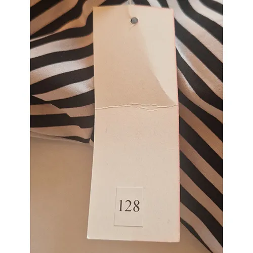 Rochie alb-negru cu dungi, destinata copiilor, cu maneci scurte, gat rotund cu cravata decorativa frontala, talie elastica si fusta nivelata. Dimensiunea 128.